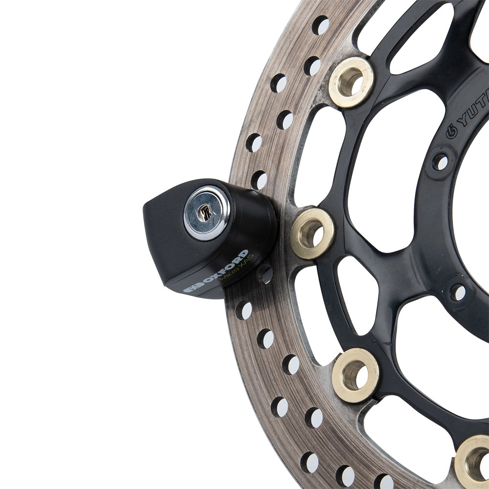 Oxford Micro XA5 Alarm Disc Lock Black / Black, fitted to a motorcycle brake disc