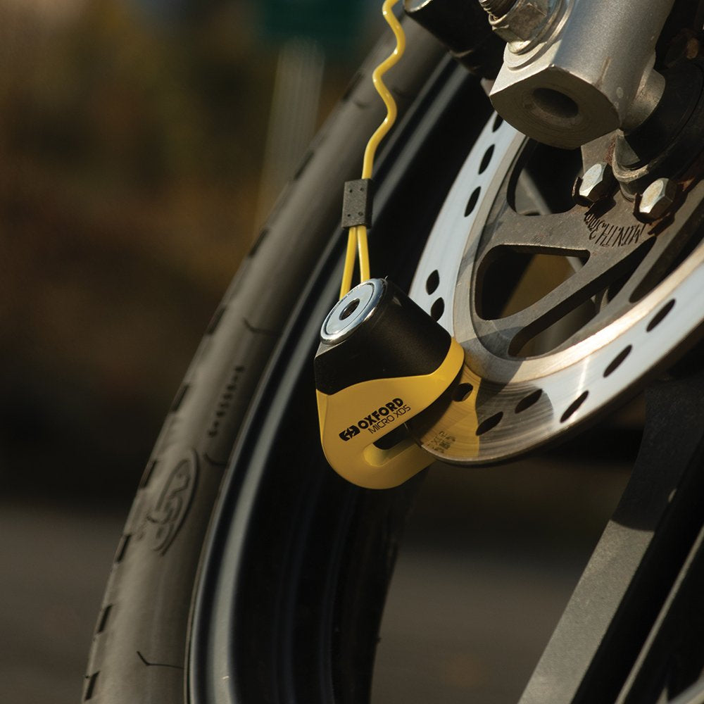 Oxford Micro XD5 Disc Lock Yellow / Black, fitted to a motorcycle brake disc