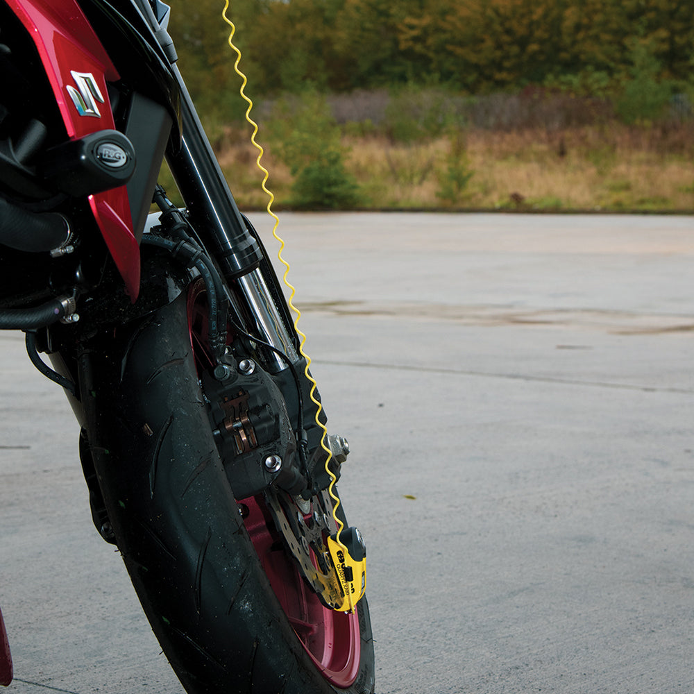 Oxford Mini Minder Disc Lock Reminder Cable Yellow, fitted to a motorcycle wheel
