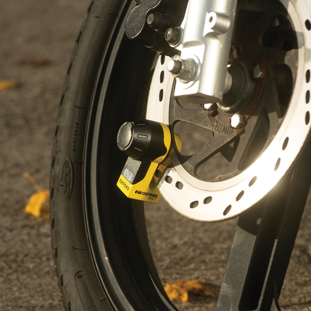 Oxford Mini T Disc Lock Yellow, fitted to a motorcycle brake disc