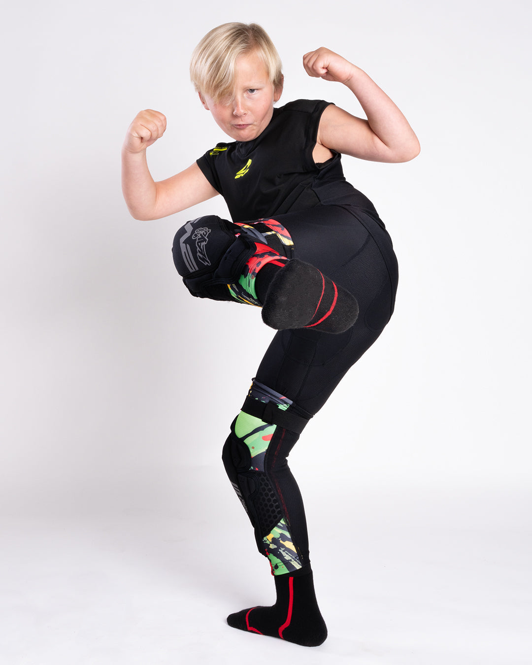 EVS Slayco Youth Knee Guards Explosion Red / Yellow / Green worn by a youth rider
